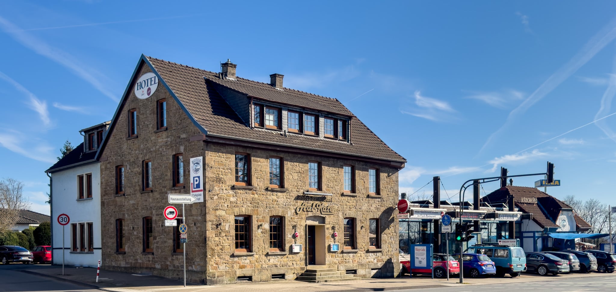 Traditionelles Hotel- und Fischrestaurant Aal-Kate in Wuppertal mit historischer Fassade, eigener Räucherei und Parkplatz bei sonnigem Wetter.